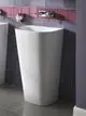 Weißer Stehtoilette von Ideal Standard, mit schmalen, modernen Linien. Im Hintergrund lila Fliesen und Chrom-Wasserhahn, begehbarer grauer Boden.